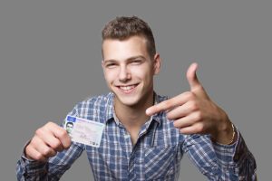 Proud teen points to new driver’s license