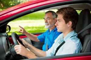 Teenager learning to drive with driving instructor